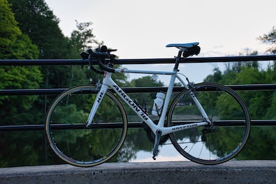 white road bike leaning on wall